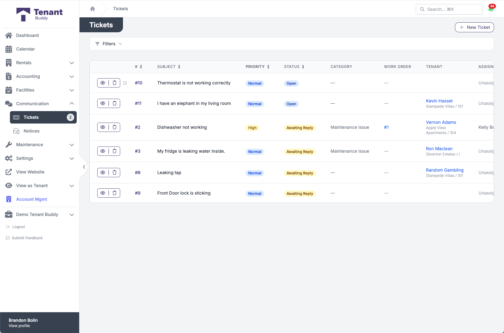 Maintenance ticket queue in Tenant Buddy showing ticket numbers, subjects like Thermostat not working and Dishwasher not working, priority badges, status badges for Open and Awaiting Reply, categories, linked work orders, tenants, and assignment